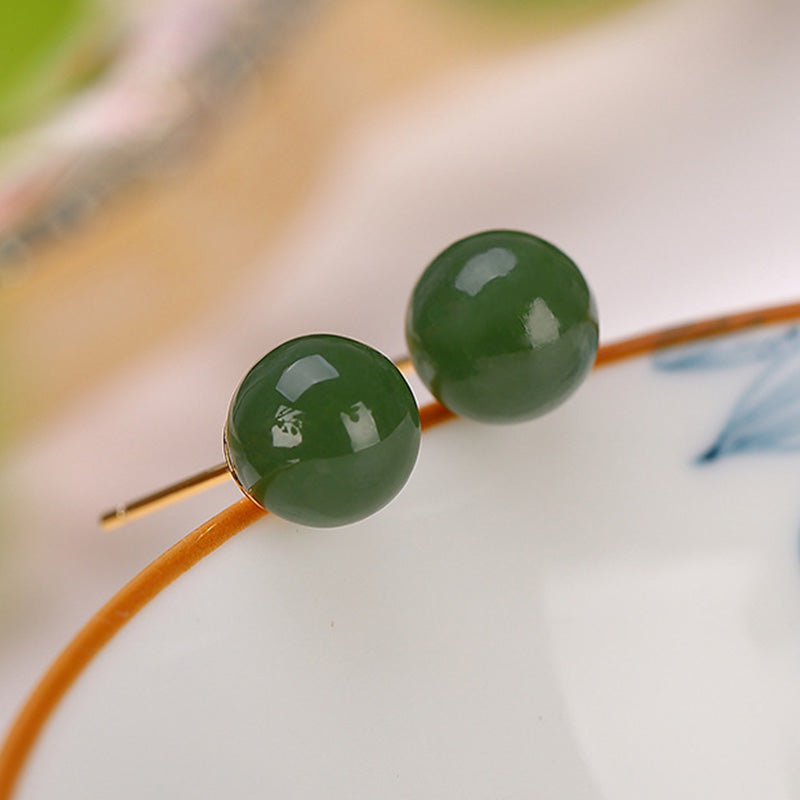 925 Silver Cyan Jade Healing Stud Earrings – forest green jade beads on cream porcelain with amber rim, selective focus macro shot