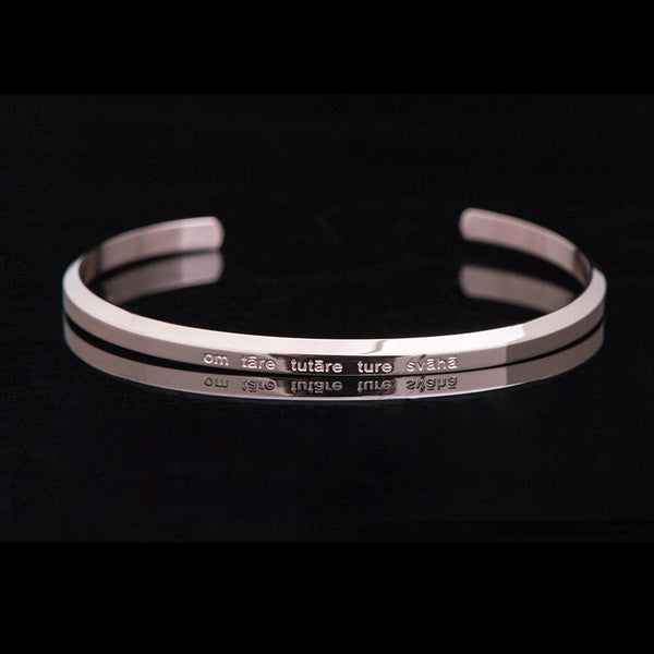 Om Mani Padme Hum Engraved Bracelet – silver cuff with raised ridges and mantra text, minimalist bangle
