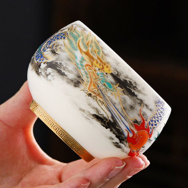 Dragon Playing Pearl Porcelain Teacup – Gold dragon with cobalt scales in ink-wash clouds, hand-held artisan craft