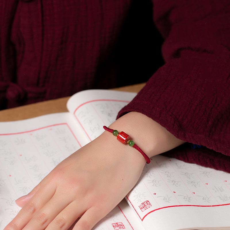 Tibetan Cinnabar Braided Rope Bracelet – On wrist with calligraphy paper, traditional red string jewelry