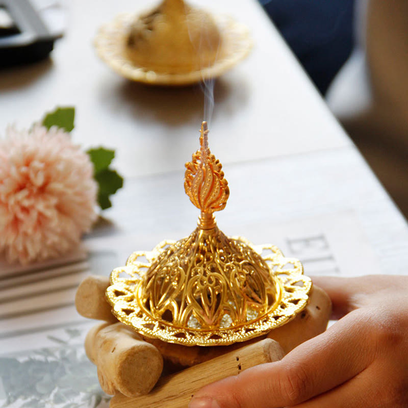 Gold Alloy Mini Incense Burner – ornate dome lid held in hand on marble table with pink flower accent, gold incense holder