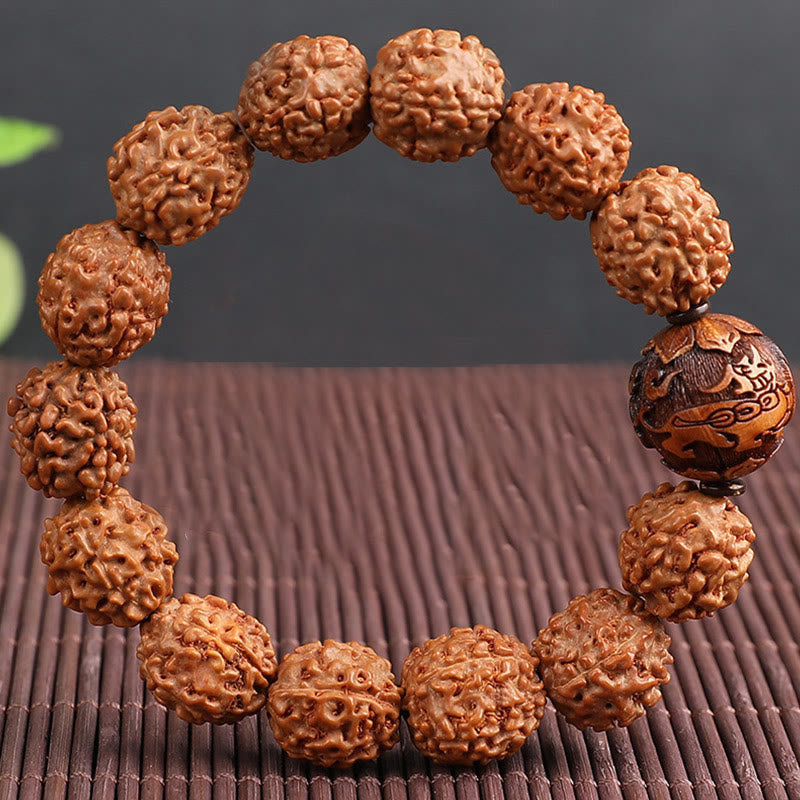 Rudraksha PiXiu Bracelet – Close-up of beads and carved coin bead on brown bamboo mat, texture