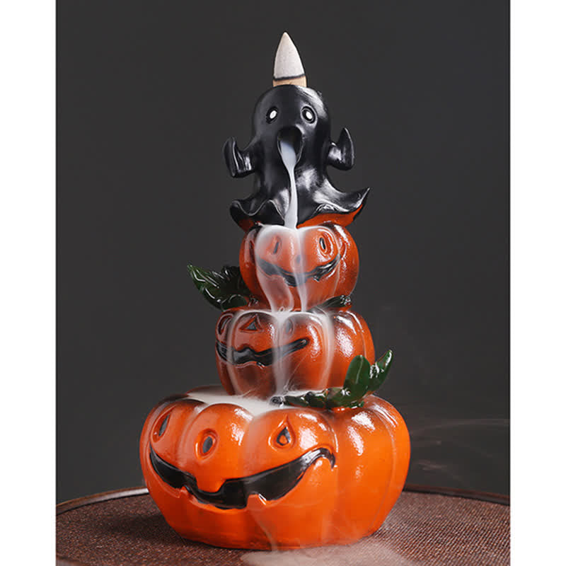 Horned ghost atop pumpkin stack, backflow smoke pouring from mouth through jack-o-lanterns, green leaves, brown mat – Halloween backflow burner