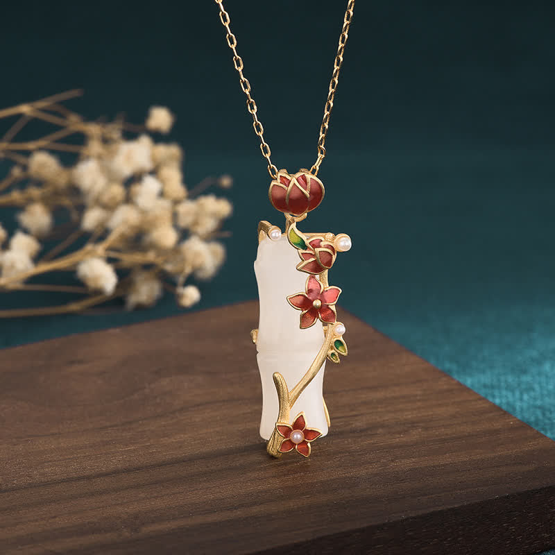White Jade Bamboo Lotus Necklace – Gold bamboo pendant with red enamel flowers and pearls on dark wood, jade necklace