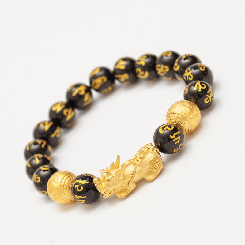 FengShui PiXiu Obsidian Wealth Bracelet - Elevated angle on white, complete bracelet with gold Pixiu and mantra beads