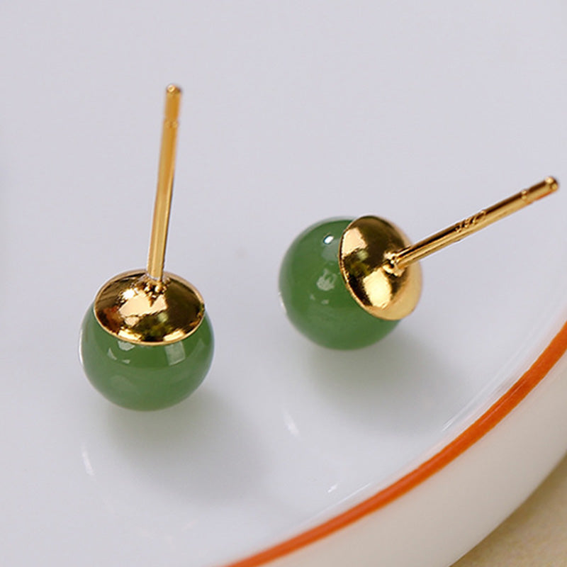 925 Silver Cyan Jade Healing Stud Earrings – sage green jade studs on white ceramic dish with orange rim, elevated three-quarter view