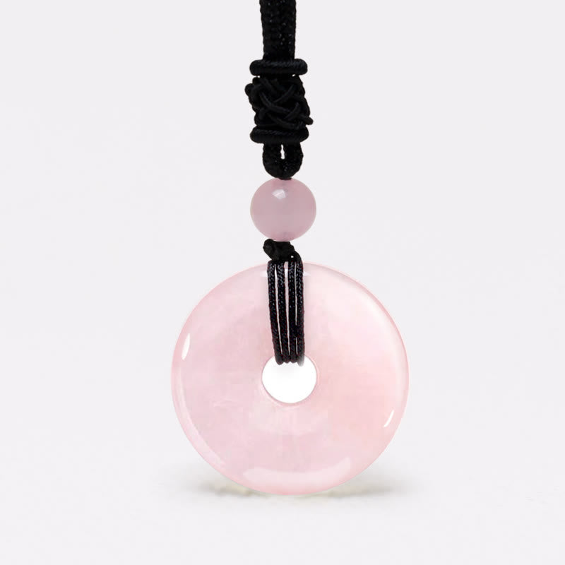 Lucky Coin Pendant Healing Crystal Gemstone Necklace – Soft pink rose quartz bi disc pendant on black knotted cord, white background