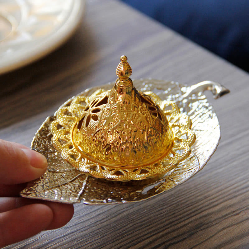 Tibetan Gold Leaf Coaster Incense Burner – Gold filigree dome on leaf tray held by hand on wood, brass meditation decor