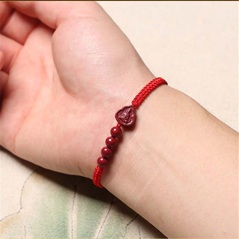 Cinnabar Laughing Buddha Guan Yin Bracelet – woven red cord with carved Buddha bead and accent beads, worn on wrist lifestyle