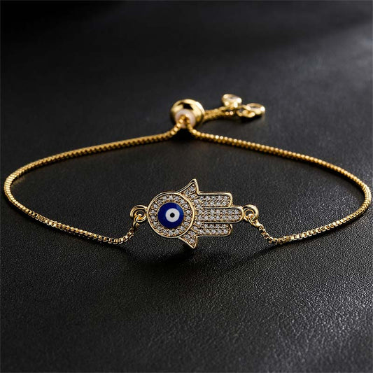 Gold Hamsa Hand Evil Eye Bracelet with Pavé Crystals on Black Background, Protection Jewelry