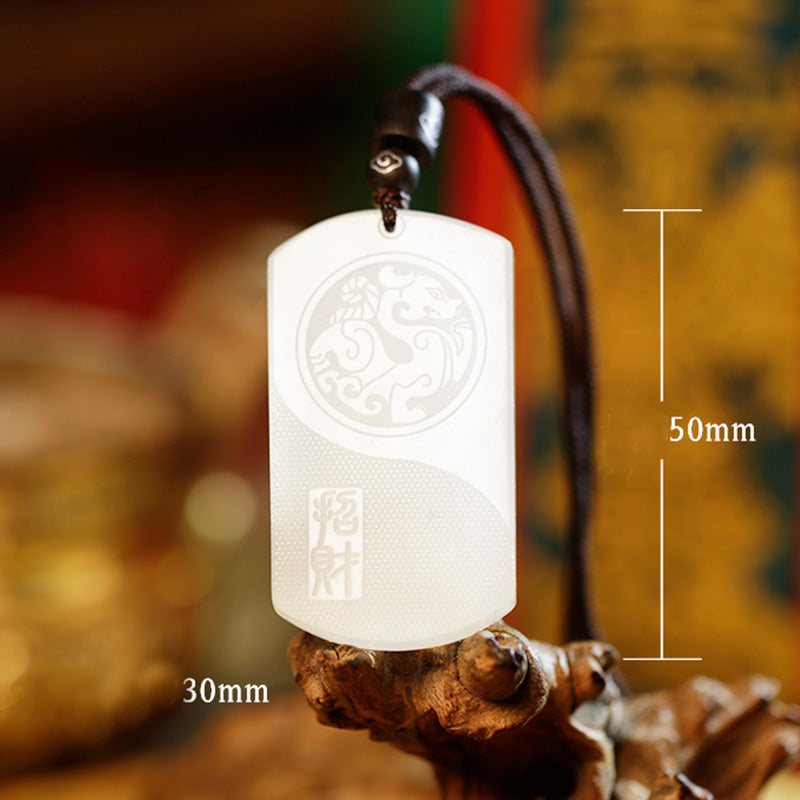 White Jade PiXiu Pendant – White jade PiXiu pendant with dimension markers 30mm by 50mm on wooden stand