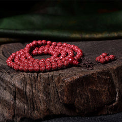 108 Mala Beads Cinnabar Bracelet – Low angle on wooden slab, carved red beads