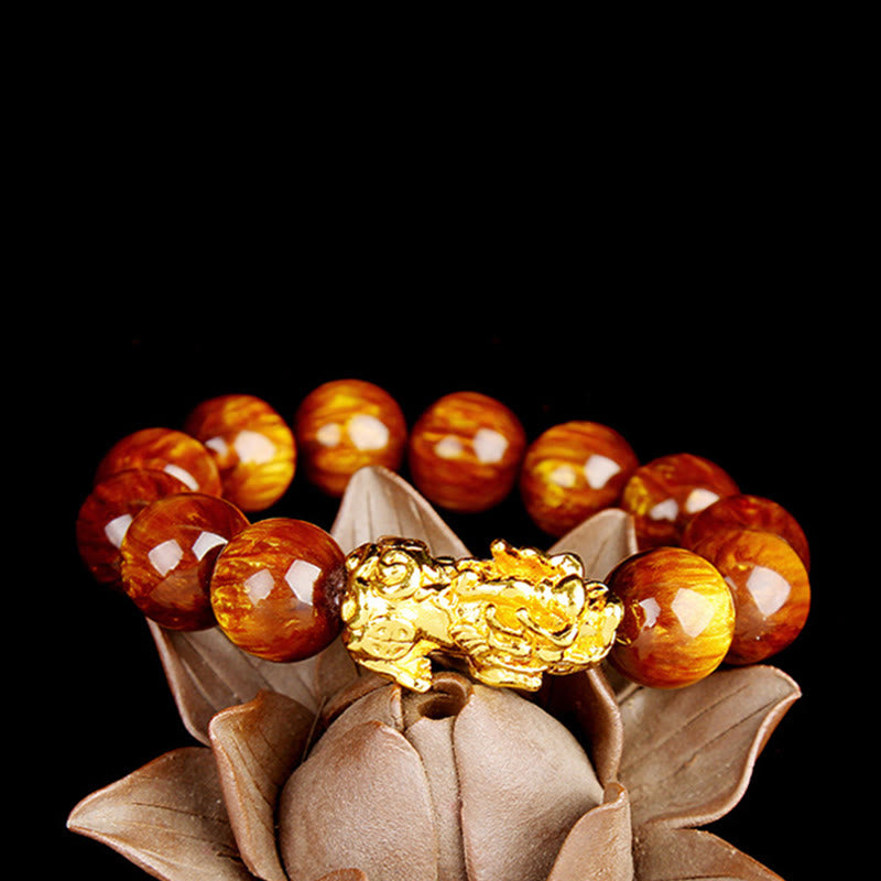 Golden Tiger Eye Bracelet – Resting on lotus flower stand on black, abundant charm