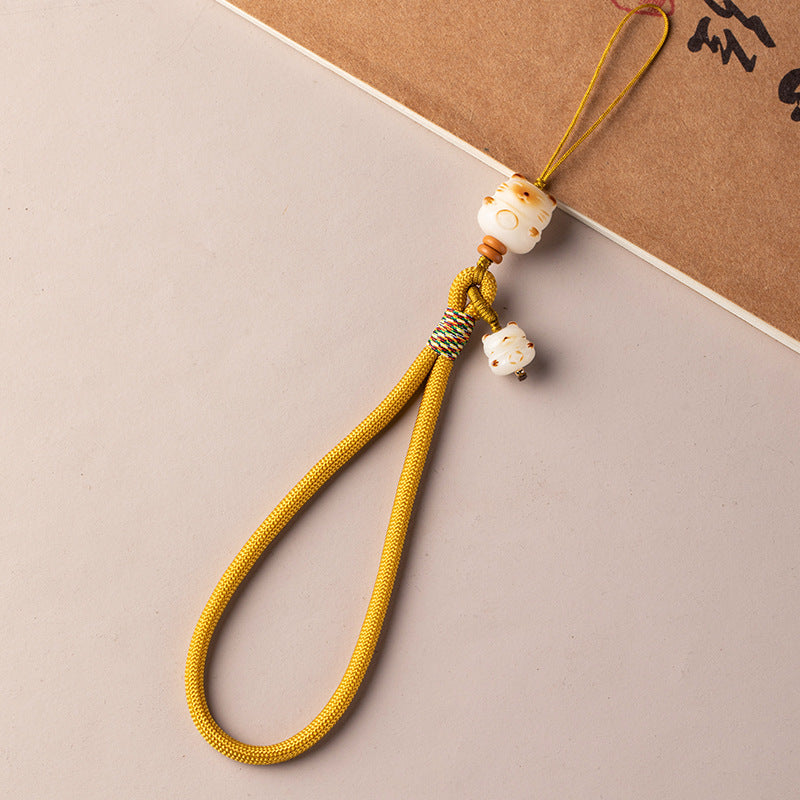 Bodhi Maneki Neko phone strap in yellow cord with carved cat bead charm and small bell