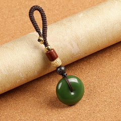 Natural green agate ping an kou peace buckle keychain on cork surface