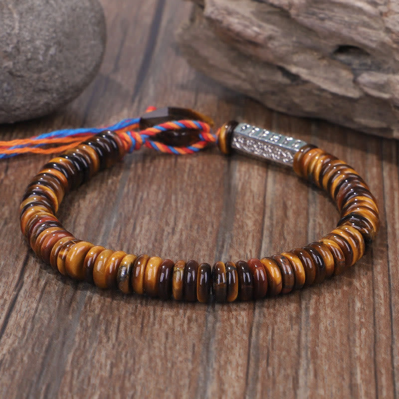 Tiger Eye Om Mani Padme Hum Bracelet - angled view on weathered wood, adjustable cord