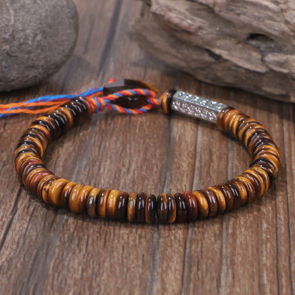 Tiger Eye Om Mani Padme Hum Bracelet - angled view on weathered wood, adjustable cord
