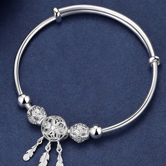 Dream Catcher Blessing Bracelet – Top-down flat lay of silver bangle with dreamcatcher charms, overhead view