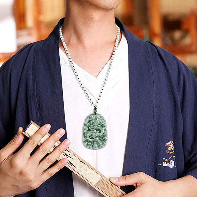 Chinese Zodiac Dragon Jade Necklace - Model wearing jade dragon pendant over navy robe with fan, Prosperity
