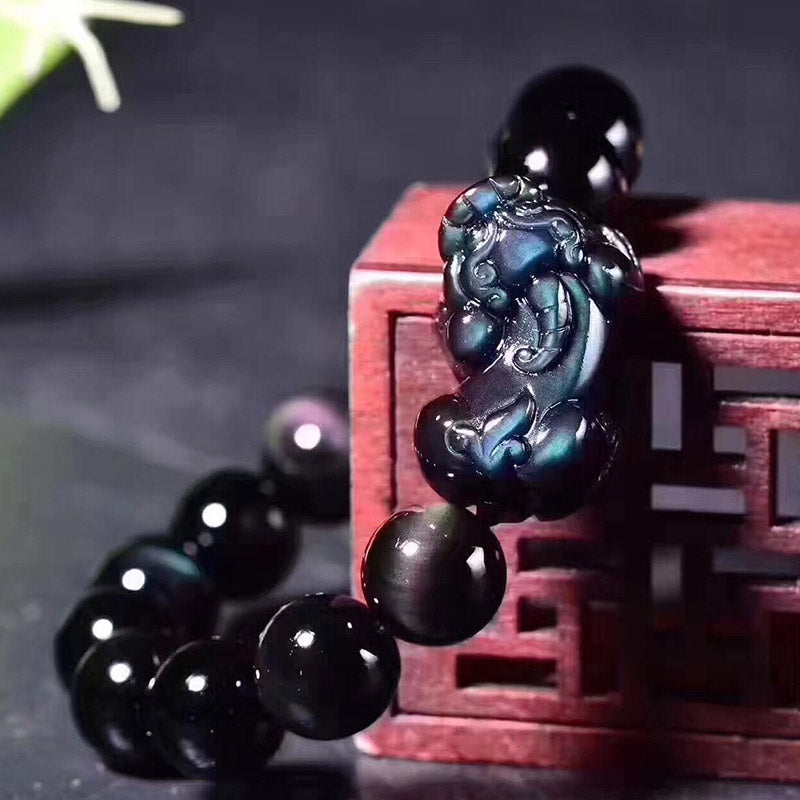 Feng Shui Rainbow Obsidian Bracelet – Pixiu closeup red wood block blue glow, carved detail, wealth