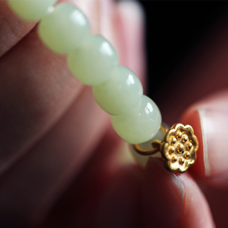 Jade Lotus Abundance Bracelet – Gold lotus pod charm detail on jade strand with finger scale, carved lotus charm