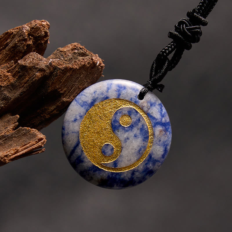 Yin Yang Crystal Necklace – Blue sodalite round pendant with gold yin-yang symbol, natural blue and white marbled stone on bl