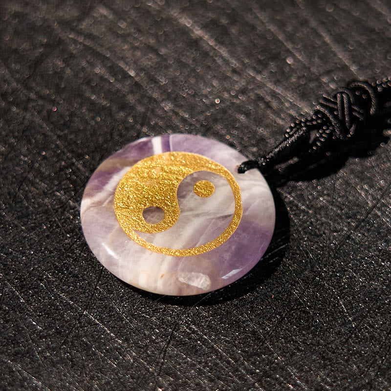 Yin Yang Crystal Necklace – Circular amethyst stone pendant with gold yin-yang inlay, purple and white natural banding on bla