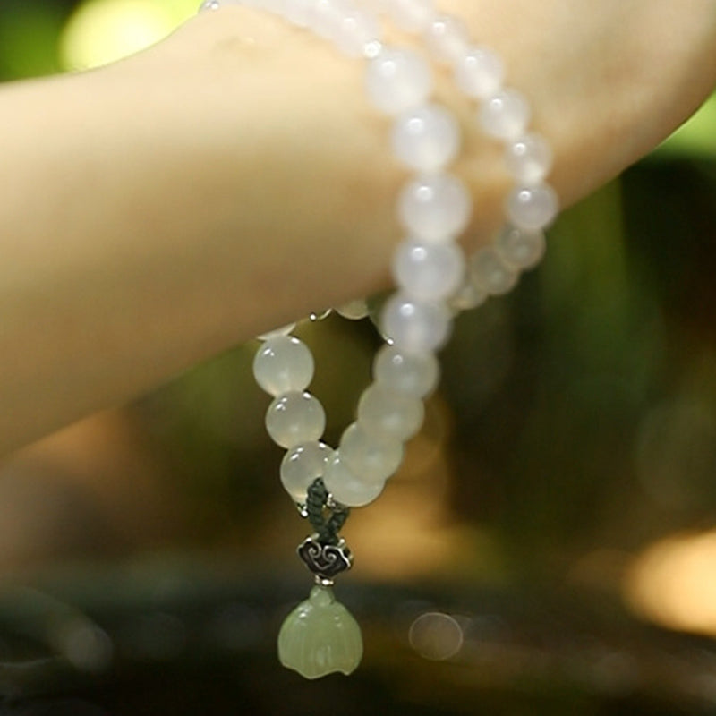 White Agate Jade Lotus Bracelet - Multi-strand with silver cloud charm and carved green lotus pendant on wrist, beaded wrap