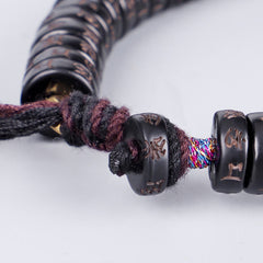 Coconut Shell Om Mani Padme Hum Bracelet – carved dark beads with multicolor cord threads and gold fitting, macro bead detail shot