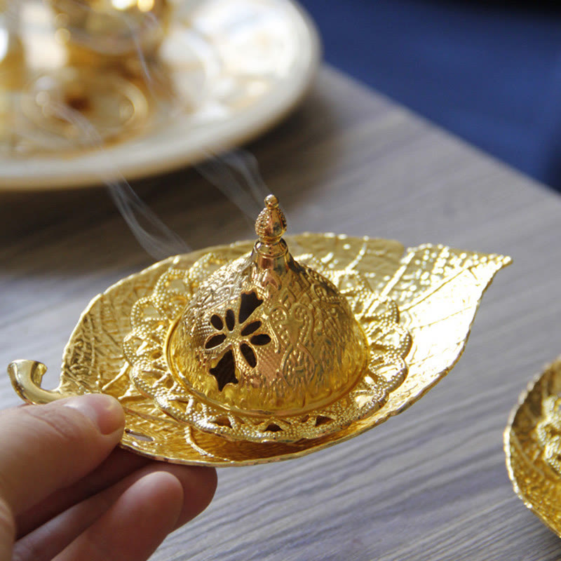 Tibetan Gold Leaf Coaster Incense Burner – Hand holding gold burner with smoke and matching set in background, brass incense holder