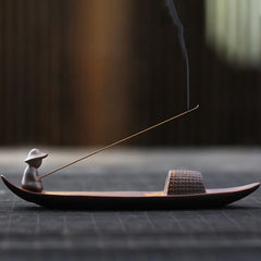 Lonely Fisherman Incense Burner – Boat-shaped ceramic with smoke rising on dark wood, zen art