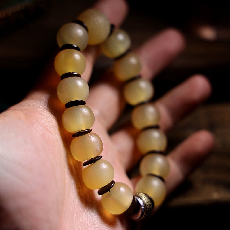 Tibetan Sheep Horn Skull Bracelet – Held on palm showing amber horn beads and dark spacer detail