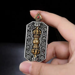 Dorje Vajra Rope Pendant – Held in hand showing dual-tone metalwork and coral stone, ethnic amulet