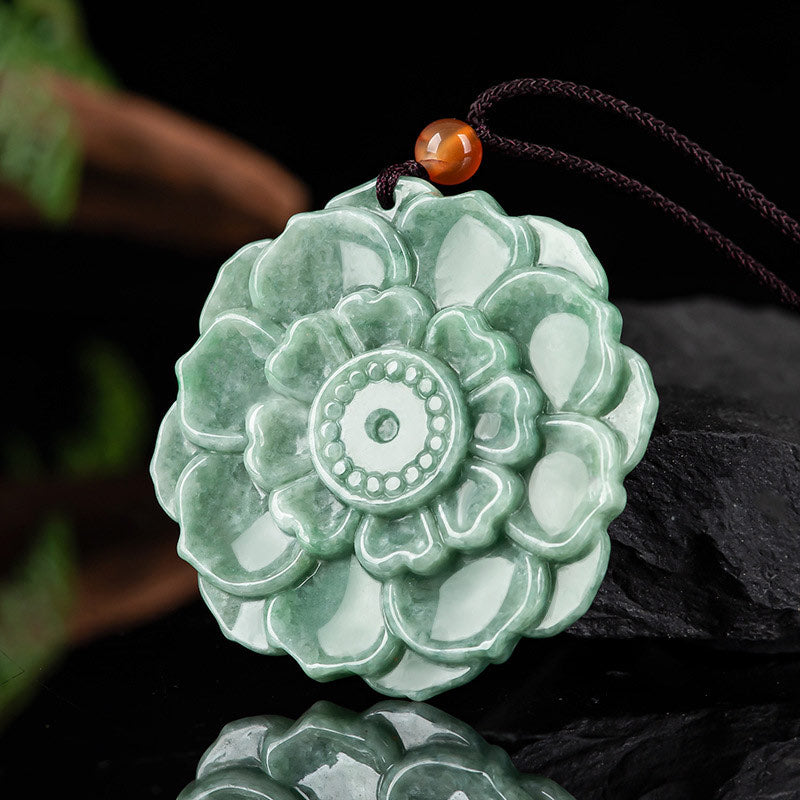 Jade Lotus Pendant Necklace – mottled jade lotus medallion on black reflective surface, Prosperity