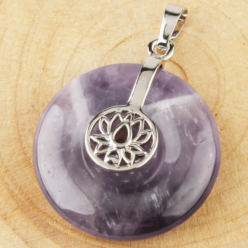 Crystal Amethyst Pink Crystal Lotus Necklace – Amethyst lotus donut pendant top-down view on natural wood grain, silver bail detail