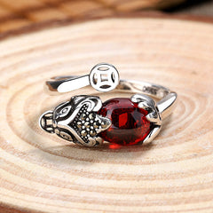 Feng Shui Garnet Pixiu Ring – front view on wood slice, red garnet center with silver pixiu wealth protection ring