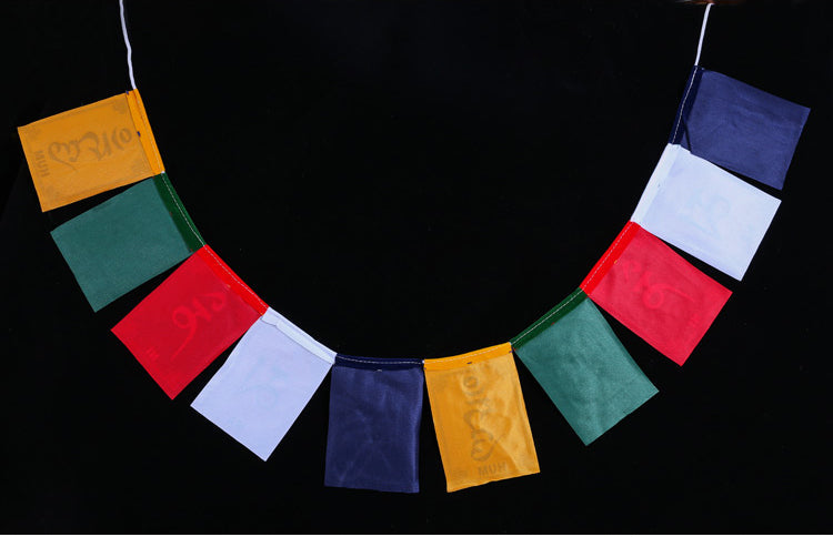Tibetan Prayer Flags – Five-color silk-style flags on black backdrop with subtle embossed mantras, prayer banner
