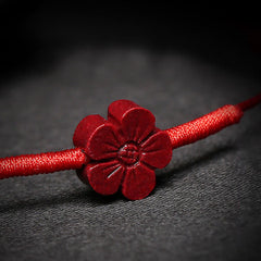 Cinnabar PiXiu Lotus Koi Fish Blessing Braid Bracelet – macro close-up of carved cinnabar flower petal details on red string, blessing bracelet