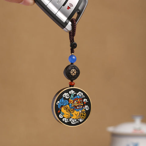 PiXiu Coin Keychain – Colorful PiXiu medallion on car key with blue bead and ebony accent Image principale du produit