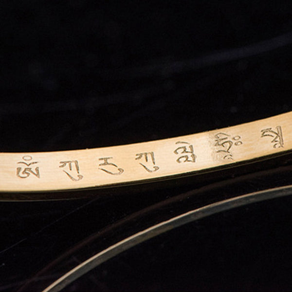 Om Mani Padme Hum Engraved Bracelet – gold band macro showing Tibetan mantra engraving, detail shot