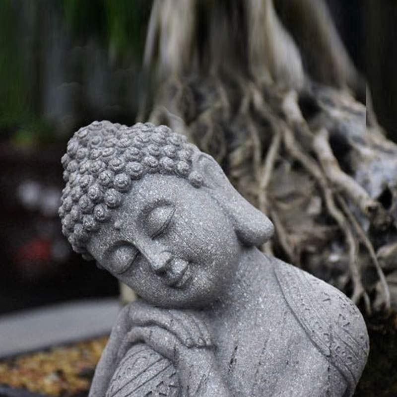 Tibetan Meditation Buddha Resin Decoration – closeup of Buddha face with closed eyes and textured stone finish, natural root backdrop, detail
