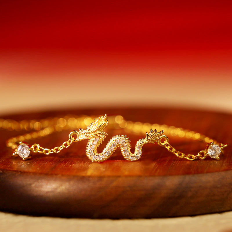 925 Silver Dragon Bracelet - Gold chain dragon with pavé on wood stand, warm bokeh, auspicious