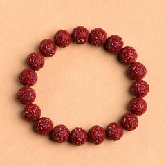 Cinnabar Om Mani Padme Hum Bracelet – scrollwork carved crimson beads flat lay, beaded cinnabar jewelry