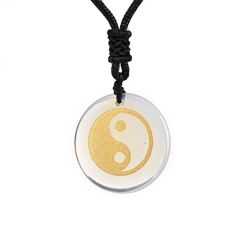 Yin Yang Crystal Necklace – Clear quartz round pendant with gold yin-yang symbol on black cord, transparent polished stone, m
