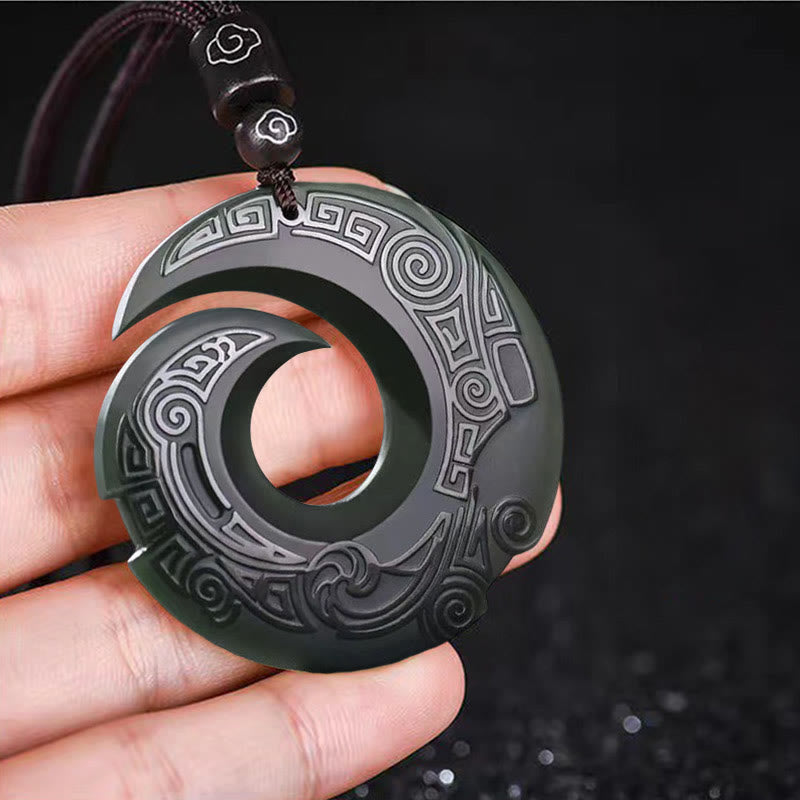 Hetian Cyan Jade Peace Buckle Luck Necklace – Hand-held view of carved dark jade pendant with interlocking crescent design, traditional Chinese geometric patterns