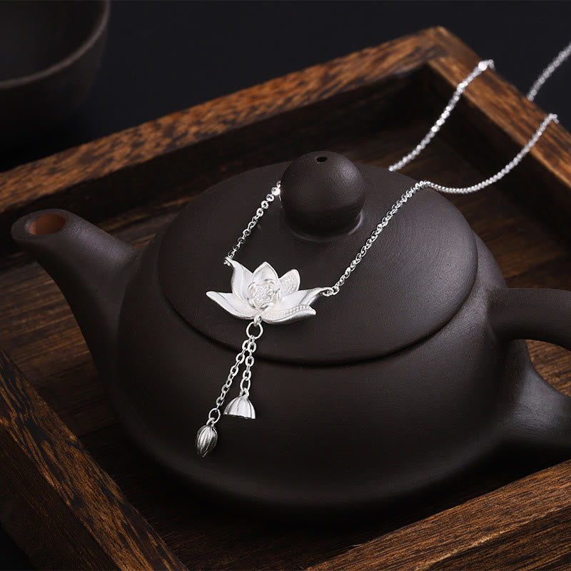 999 Silver Lotus Pod Necklace – Lotus pendant resting on dark Yixing teapot in wooden tray, artisan silver jewelry