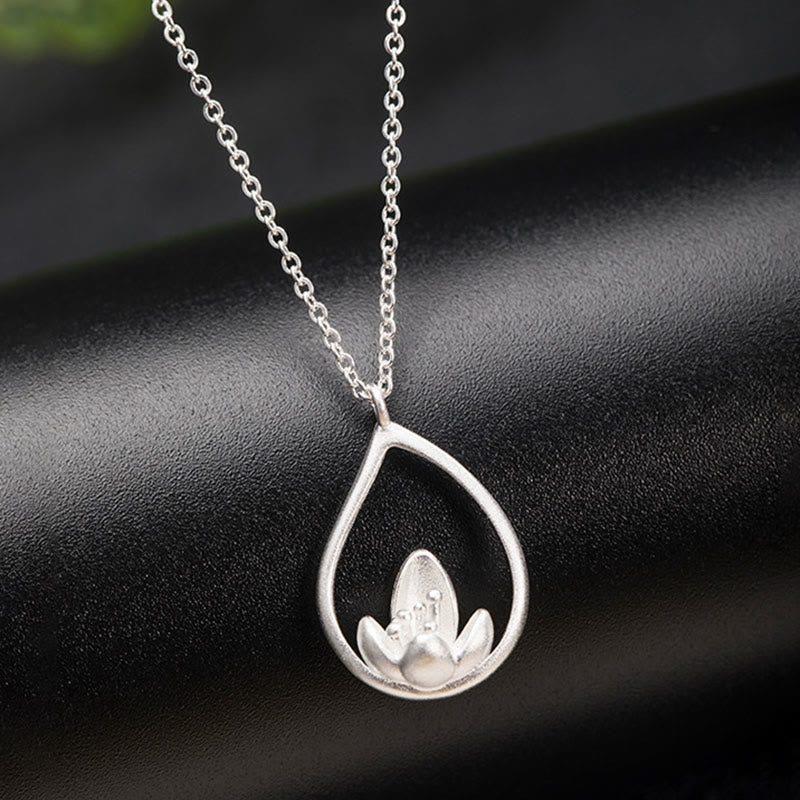 Sterling Silver Lotus Pendant – Black leather backdrop with green foliage, Minimalist