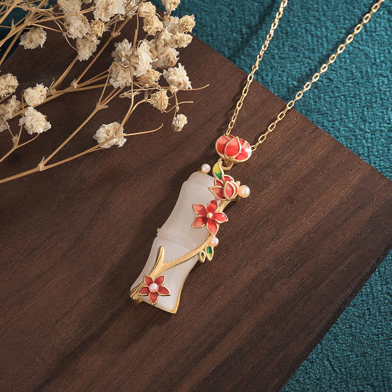 White Jade Bamboo Lotus Necklace – Jade pendant with gold floral branches and pearls, teal backdrop, Asian jewelry