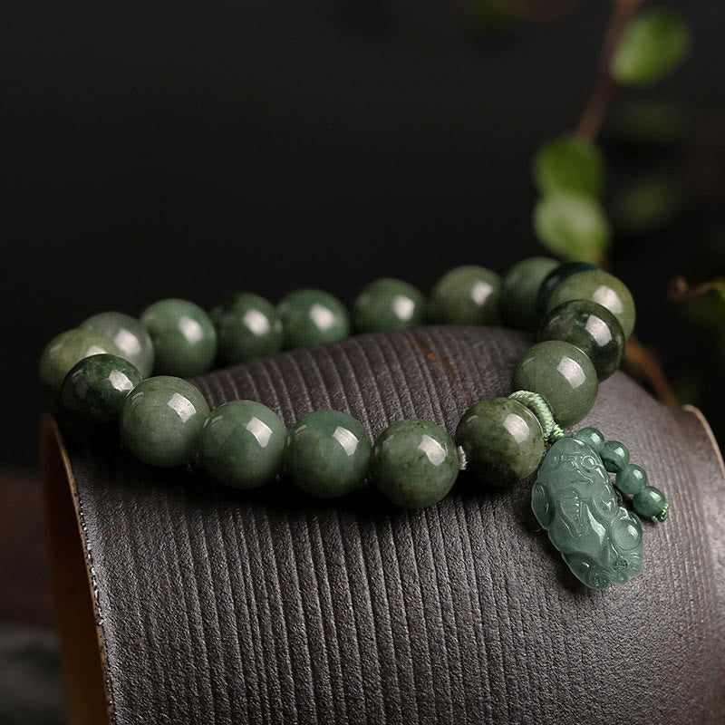 Tibetan Jade PiXiu Prosperity Bracelet – Green jade bracelet with PiXiu on curved wood surface, prosperity gift