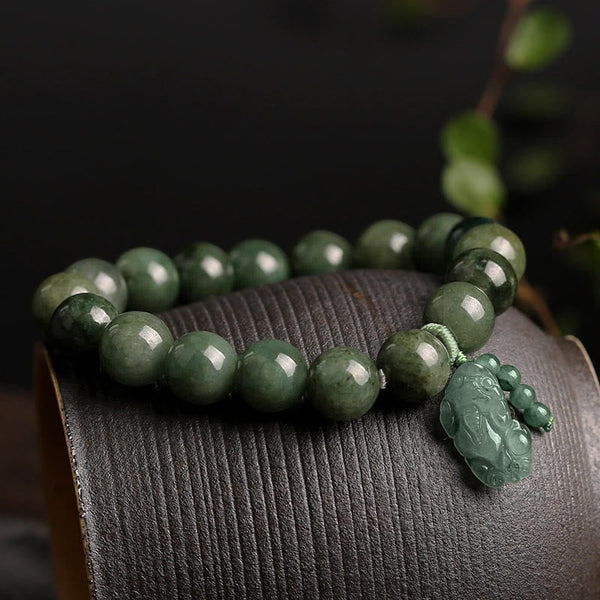 Tibetan Jade PiXiu Prosperity Bracelet – Green jade bracelet with PiXiu on curved wood surface, prosperity gift